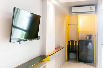 a flat screen tv on a wall in a room at A Sleep Bangkok Sathorn in Bangkok