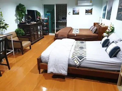 a bedroom with two beds and a desk and a chair at 297 Nature Residence in Bangkok