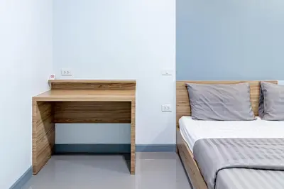 a bedroom with two beds and a desk at BeWish Residence Bangphlat in Bangkok