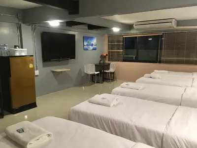 a room with three beds and a flat screen tv at ICON HOSTEL in Bangkok