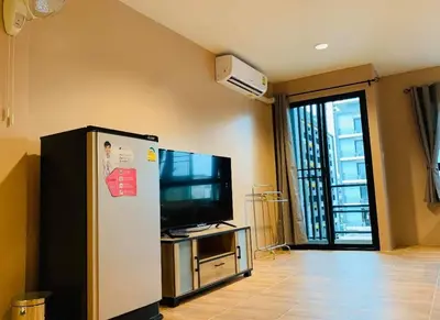 a living room with a television and a refrigerator at ICON HOSTEL in Bangkok