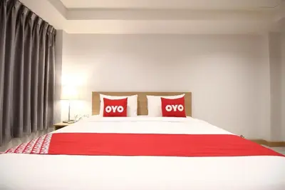 a bedroom with a large white bed with two red pillows at Super OYO 483 Pannee Hotel Khaosan in Bangkok
