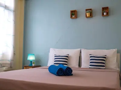 a bed with two blue pillows on top of it at Chan Cha La 99 Hostel in Bangkok