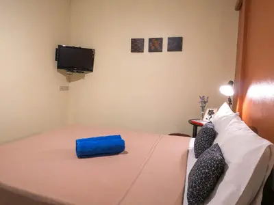 a bedroom with a bed with a blue bag on it at Chan Cha La 99 Hostel in Bangkok