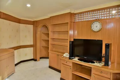 a room with a tv and a clock on the wall at The Kaze 34 Hotel and Serviced Residence in Bangkok
