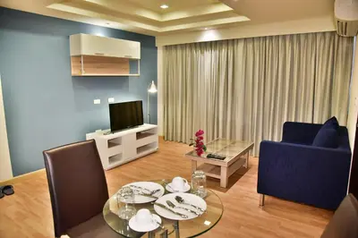 a living room with a table and a tv at The Kaze 34 Hotel and Serviced Residence in Bangkok