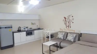a living room with a couch and a kitchen at Popular Condo C2 in Nonthaburi
