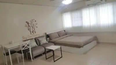 a bedroom with a bed and a couch and a table at Popular Condo C2 in Nonthaburi