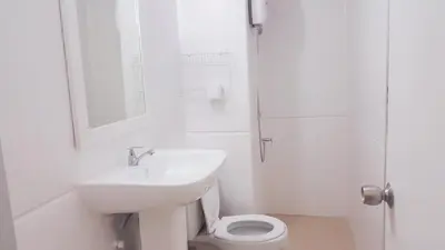 a white bathroom with a sink and a toilet at Popular Condo C2 in Nonthaburi