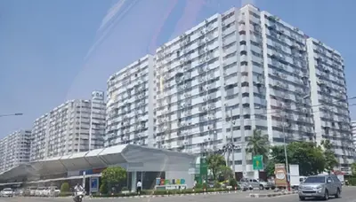 a large white building with cars in front of it at Popular Condo C9 in Pak Kret