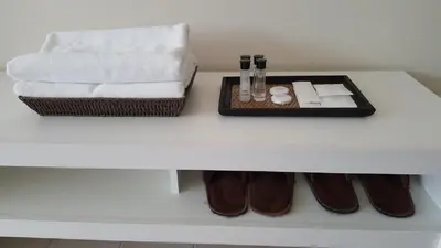 a white table with a tray of towels and shoes at Popular Condo C9 in Pak Kret