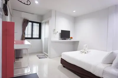 a white bedroom with a bed and a sink at Ma Non Nont Hotel & Apartment in Nonthaburi