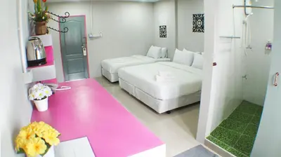 a bedroom with a white bed and a pink floor at Ma Non Nont Hotel & Apartment in Nonthaburi