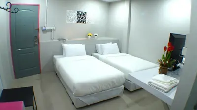 a small room with two beds and a sink at Ma Non Nont Hotel & Apartment in Nonthaburi