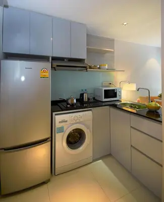 a kitchen with a refrigerator and a washing machine at The Present Sathorn in Bangkok