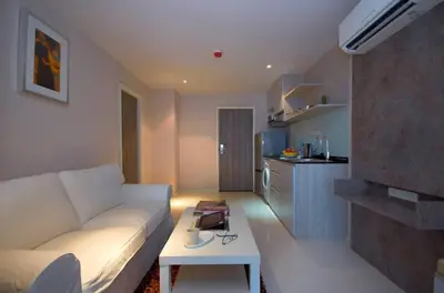 a living room with a white couch and a table at The Present Sathorn in Bangkok