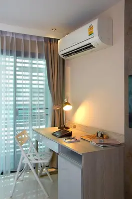 a kitchen with a stove and a counter with a chair at The Present Sathorn in Bangkok