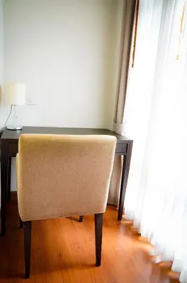 a chair sitting at a desk next to a window at Siam Bright Suite in Bangkok