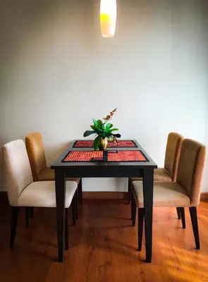 a dining room table with chairs and a plant on it at Siam Bright Suite in Bangkok