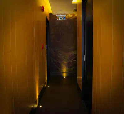 a dark hallway with a sign on the wall at Siam Bright Suite in Bangkok