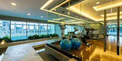 a gym with treadmills and exercise equipment in a building at Jasmine Grande Residence in Bangkok
