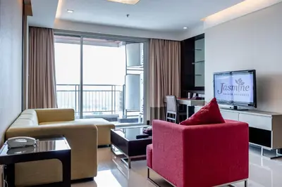 a living room with a couch and a tv at Jasmine Grande Residence in Bangkok