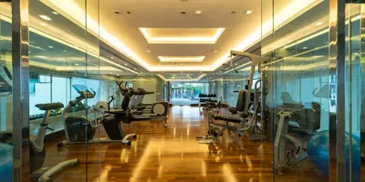 a gym with treadmills and ellipticals in a building at Jasmine Grande Residence in Bangkok