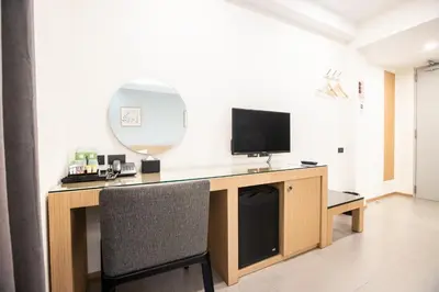a room with a desk with a television and a mirror at Cubic Bangna in Bangkok