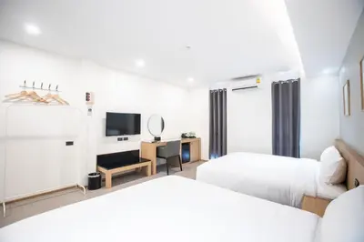 a hotel room with two beds and a television at Cubic Bangna in Bangkok