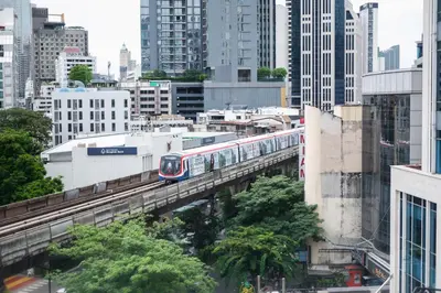 a train on a bridge in a city at Ruamchitt Plaza Hotel in Bangkok