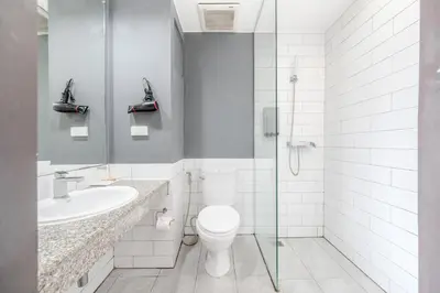 a bathroom with a toilet and a sink and a shower at Ruamchitt Plaza Hotel in Bangkok