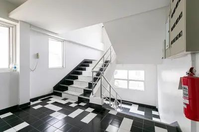 a staircase in a room with a black and white tiled floor at Ruan Plaisoi Apartment in Bangkok