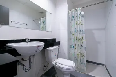 a bathroom with a sink and a toilet and a shower at Ruan Plaisoi Apartment in Bangkok