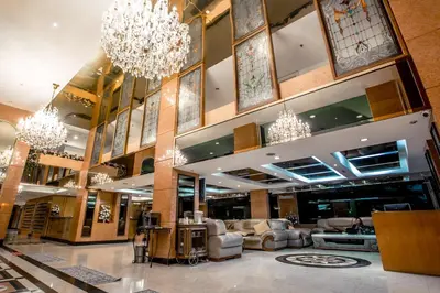 a lobby with chandeliers and furniture in a mall at Hope Land Hotel Sukhumvit 24 in Bangkok