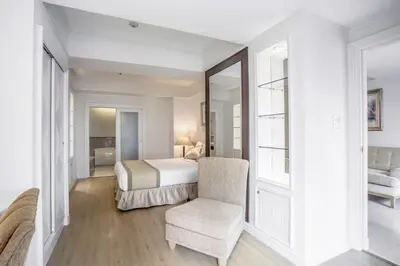 a bedroom with a bed and a chair and a mirror at Hope Land Hotel Sukhumvit 24 in Bangkok