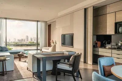 a living room with a table and chairs at Four Seasons Hotel Bangkok at Chao Phraya River in Bangkok