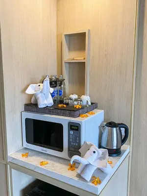 a microwave on a counter with towels on top of it at Eleven Hotel Bangkok Sukhumvit 11 in Bangkok