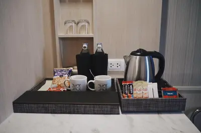 a tray with cups of coffee and snacks on a counter at Eleven Hotel Bangkok Sukhumvit 11 in Bangkok