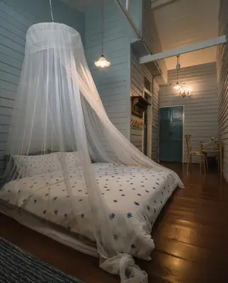 a bed with a mosquito net in a room at Lhong Yaowarat hostel in Bangkok