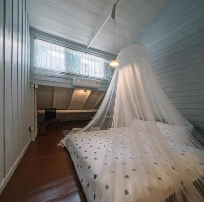 a bedroom with a bed with a mosquito net at Lhong Yaowarat hostel in Bangkok