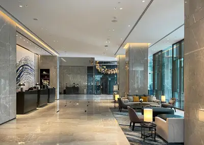 a lobby of a hotel with chairs and tables at Carlton Hotel Bangkok Sukhumvit in Bangkok