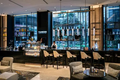 a bar at a hotel with a woman behind a counter at Carlton Hotel Bangkok Sukhumvit in Bangkok