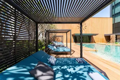 a room with a bed and a swimming pool at Carlton Hotel Bangkok Sukhumvit in Bangkok