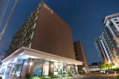 a tall building with lights on in a city at Marsi Hotel Bangkok in Bangkok