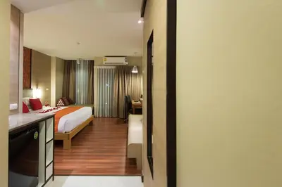 a hotel room with a bed and a desk at Marsi Hotel Bangkok in Bangkok