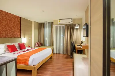 a hotel room with a bed and a desk at Marsi Hotel Bangkok in Bangkok