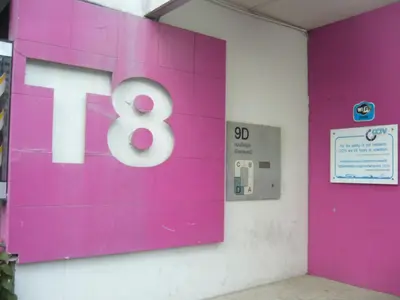 a pink sign with the number eight on a wall at Poppular Palace Don Mueang Bangkok in Bangkok