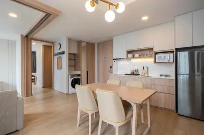 a kitchen and dining room with a wooden table and chairs at Staybridge Suites Bangkok Thonglor by IHG in Bangkok