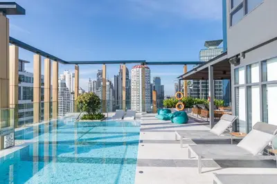 a swimming pool on the roof of a building with a city skyline at Staybridge Suites Bangkok Thonglor by IHG in Bangkok