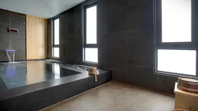 a bathroom with a tub in a room with windows at Staybridge Suites Bangkok Thonglor by IHG in Bangkok